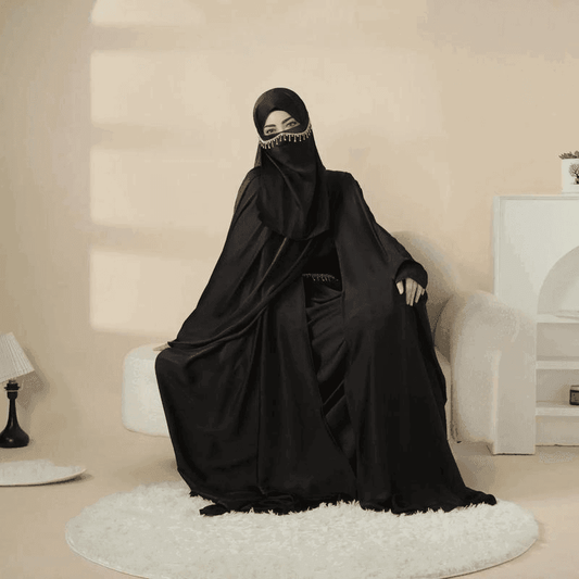 Elegant black 5 piece satin abaya set by Fabaya UK worn by a seated woman indoors