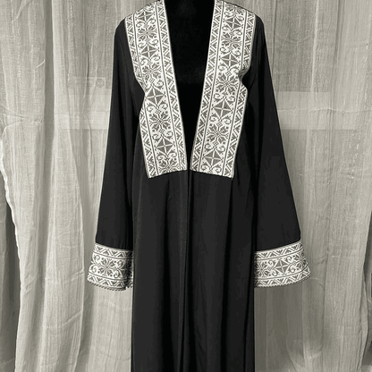 Black chiffon abaya dress for women with white intricate embroidery on front and sleeve cuffs