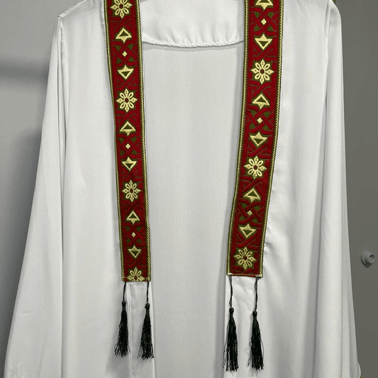 White chiffon abaya dress for women with decorative red and gold embroidered tassel detailing hanging from the neckline