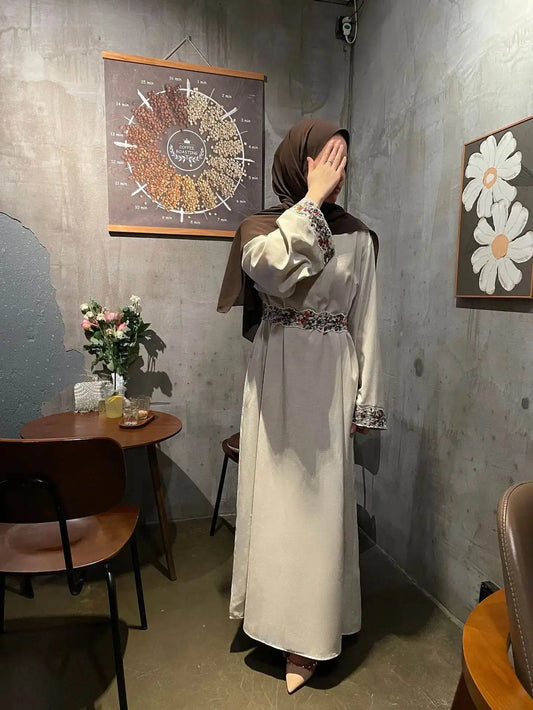 Women wearing cotton linen modest dress with embroidered cuffs and waist in cozy indoor cafe setting