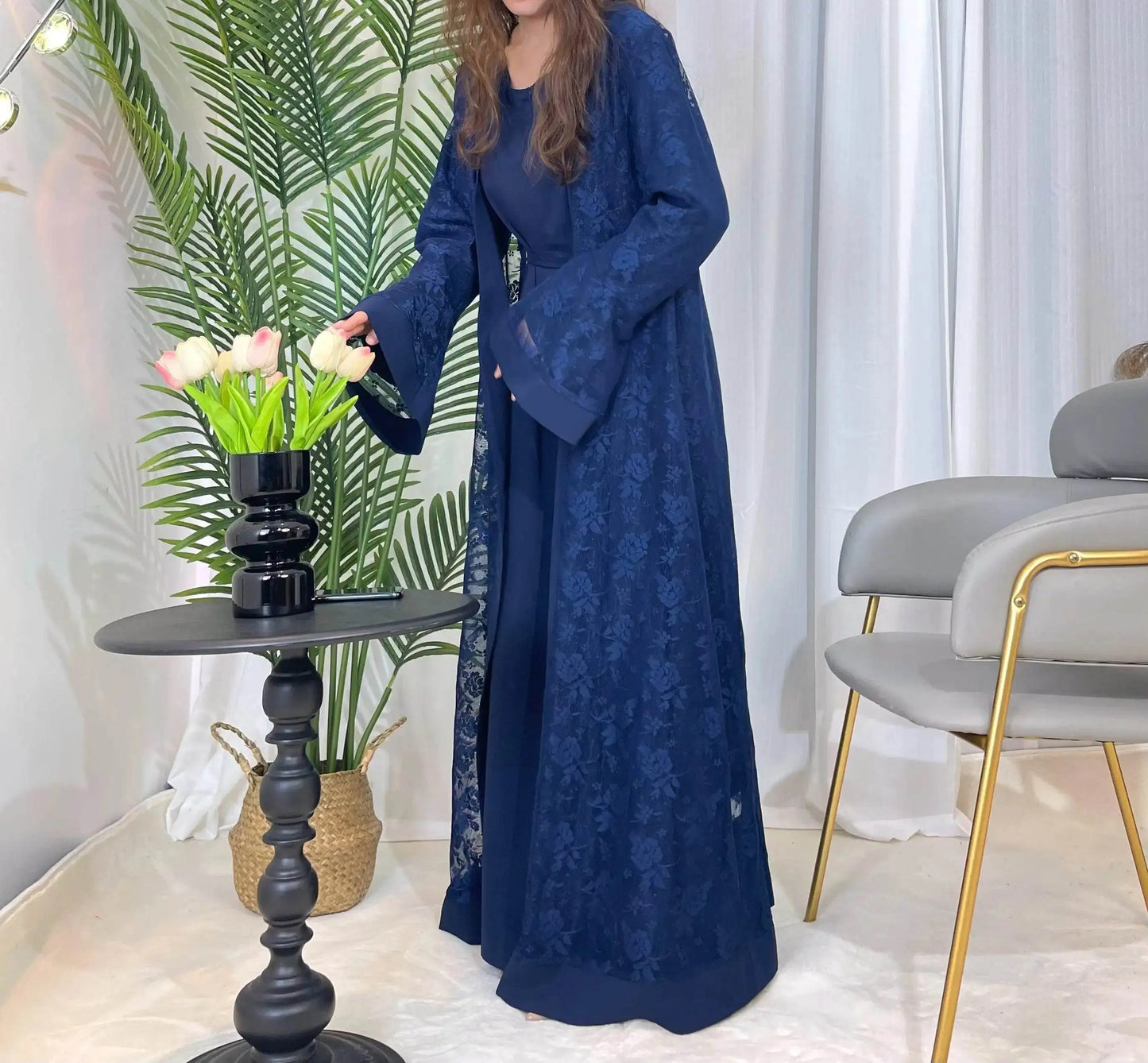 Fabaya UK navy blue lace abaya set with floral pattern worn by woman near black table and flowers