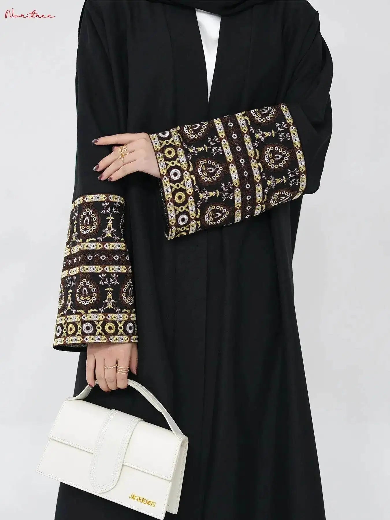 Fabaya UK black embroidered abaya kimono with intricate gold and white sleeve designs and white handbag