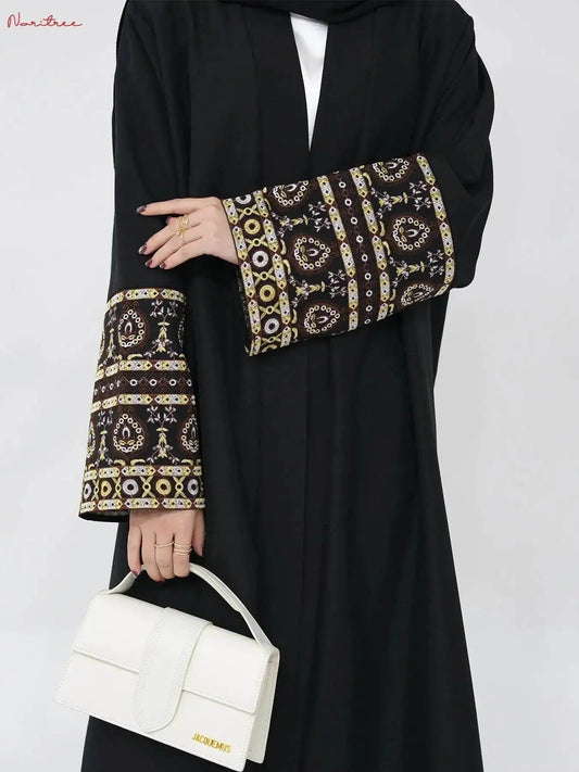 Fabaya UK black embroidered abaya kimono with intricate gold and white sleeve designs and white handbag