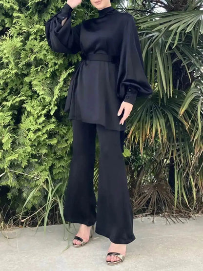 Woman wearing a shiny silky abaya set in black with puffed sleeves and wide-leg pants outdoors