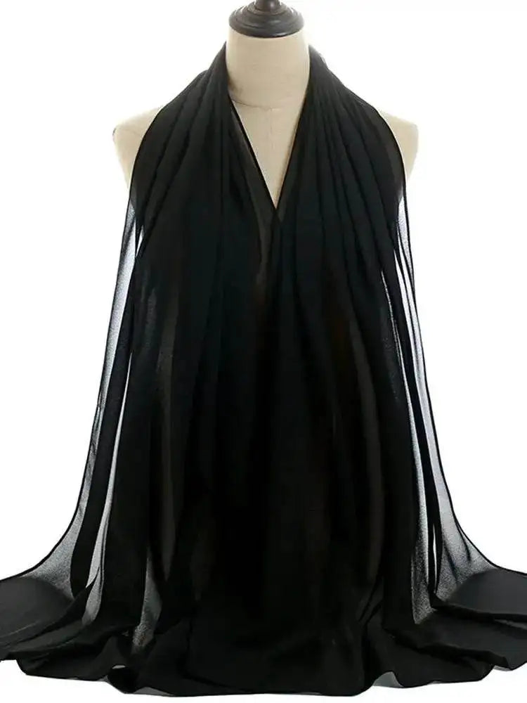 Black shiny silky abaya set draped on a mannequin showcasing smooth fabric and elegant design