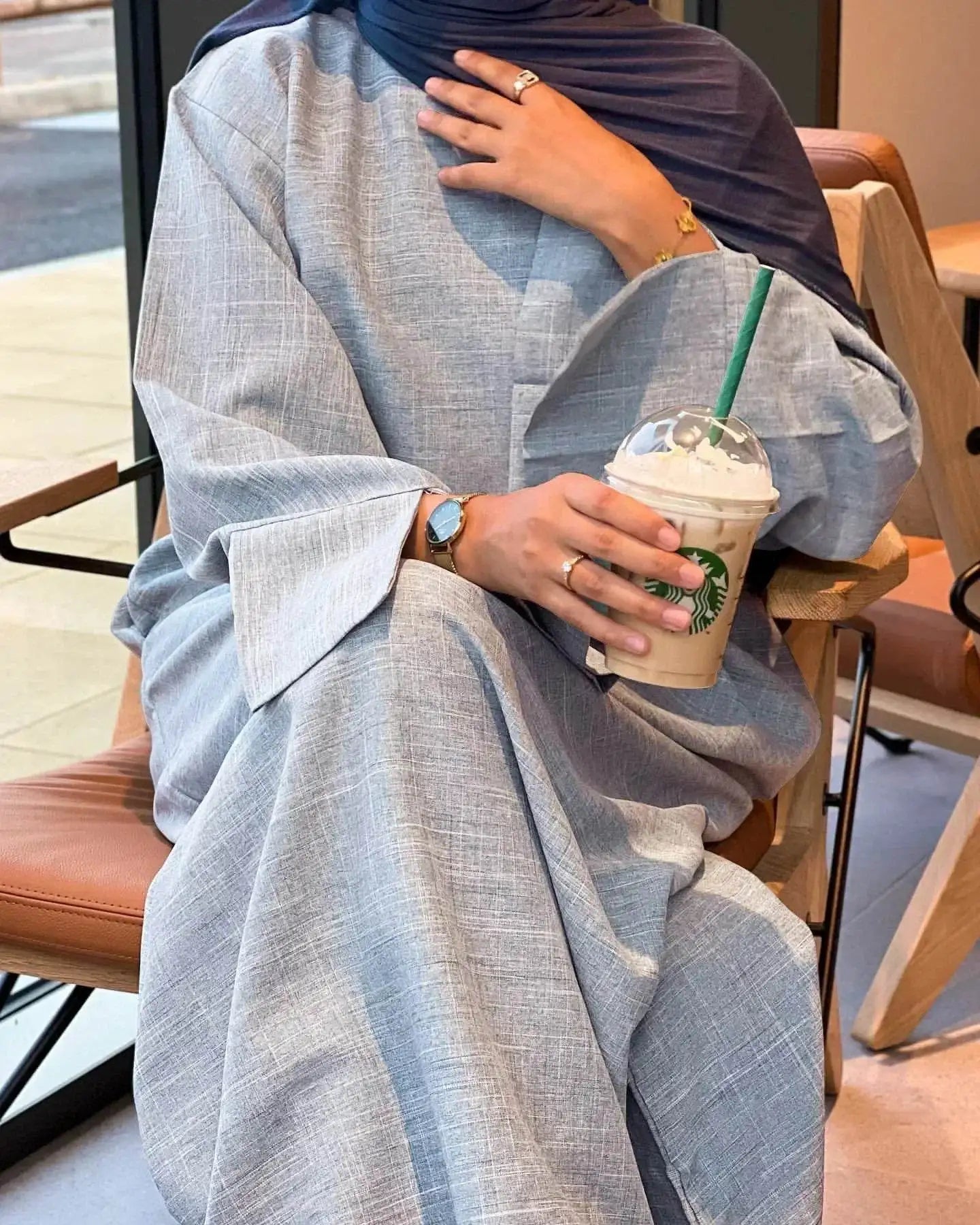 Fabaya UK luxury cotton linen abaya dress in light gray worn by woman holding Starbucks cup