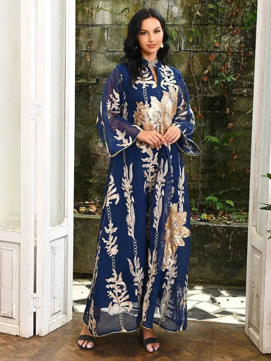Woman wearing a navy blue Moroccan embroidered abaya dress with gold floral patterns and wide sleeves