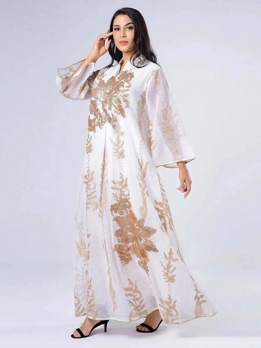 White Moroccan embroidered abaya dress with gold floral patterns worn by a woman