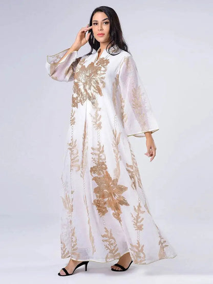 White Moroccan embroidered abaya dress with gold floral patterns worn by a woman