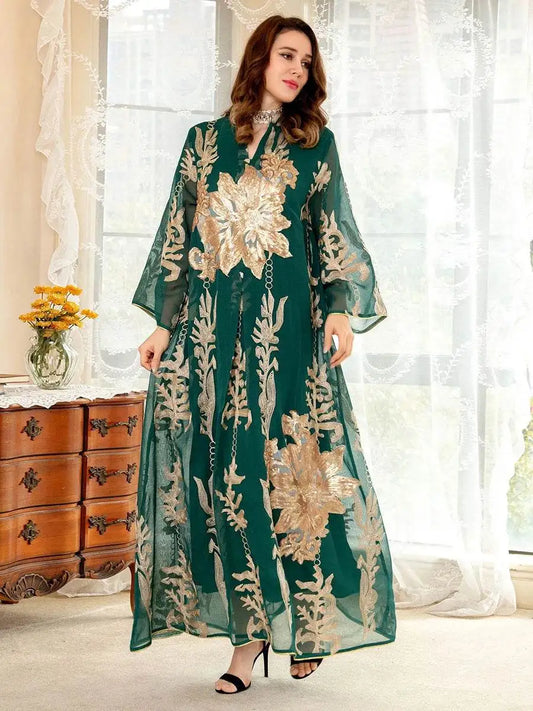 Woman wearing a green Moroccan embroidered abaya dress with intricate gold floral designs standing indoors